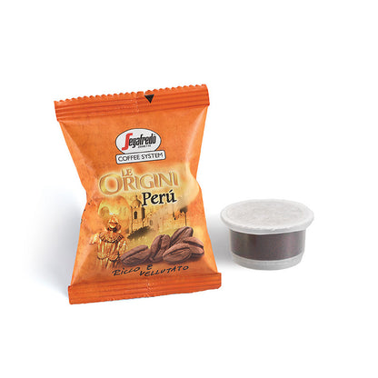 A packet of Segafredo Zanetti Segafredo Peru Single Origin Espresso Single-Serve Cartridges, featuring an image of coffee beans and a cultural scene, next to a sealed coffee pod, promises the rich chocolate tones characteristic of single origin espresso made from premium Peruvian coffee.